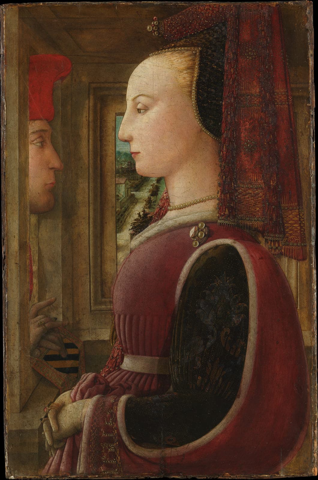 A richly dressed woman in profile inside a room; through an opening in the wall behind her, a man's face and hand appear from the other side.